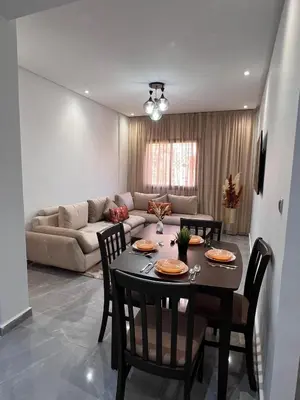 a living room with a table and chairs and a couch at Appartement familiale top one saada in Marrakech