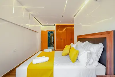 a bedroom with a bed with yellow and white pillows at VISTA HOLIDAYS ctm in Marrakech