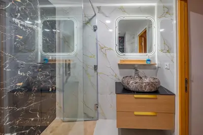 a bathroom with a glass shower and a sink at VISTA HOLIDAYS ctm in Marrakech