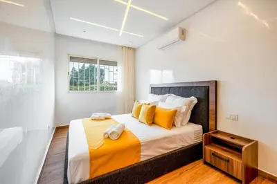 a bedroom with a large bed with yellow pillows at VISTA HOLIDAYS ctm in Marrakech