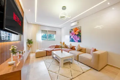 a living room with a couch and a tv at VISTA HOLIDAYS ctm in Marrakech