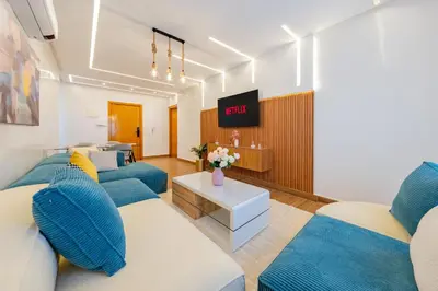 a living room with blue couches and a tv at VISTA HOLIDAYS Warda A31 in Marrakech