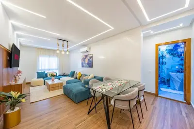 a living room with a blue couch and a table at VISTA HOLIDAYS Warda A31 in Marrakech