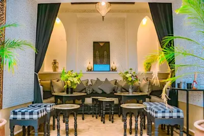 a restaurant with tables and couches and plants at Riad Clefs d'Orient in Marrakech