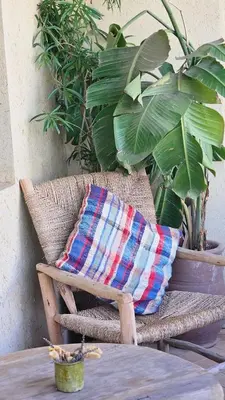 a pillow sitting on a chair next to plants at Riad Clefs d'Orient in Marrakech