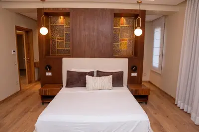 a bedroom with a white bed with wooden floors and windows at Villa 