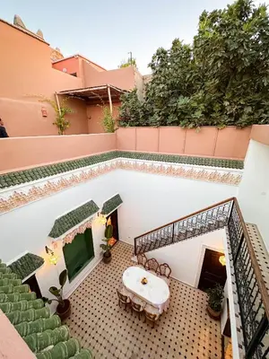 a balcony with a table and chairs on a building at Riad M Azbetz in Marrakech
