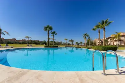 a large swimming pool with palm trees in the background at Relaxation et Confort a Prestigia -10 min du centre in Marrakech