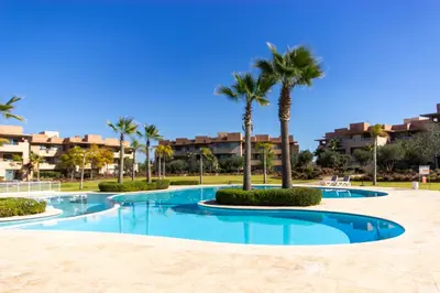 a swimming pool with palm trees in a resort at Relaxation et Confort a Prestigia -10 min du centre in Marrakech