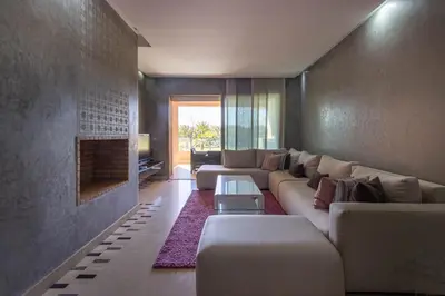 a living room with a couch and a fireplace at Relaxation et Confort a Prestigia -10 min du centre in Marrakech