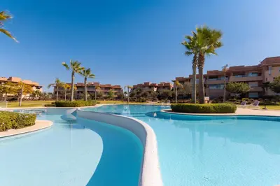 a large swimming pool with palm trees and buildings at Relaxation et Confort a Prestigia -10 min du centre in Marrakech