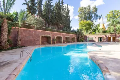 a swimming pool with blue water in a courtyard at Romantic Retreat next to M avenue in Marrakech