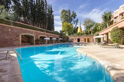 a large swimming pool with blue water at Romantic Retreat next to M avenue in Marrakech
