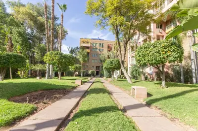 a path through a park with trees and buildings at Romantic Retreat next to M avenue in Marrakech