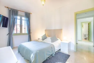 a white bedroom with a bed and a window at Romantic Retreat next to M avenue in Marrakech