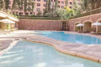 a swimming pool in a building with a building at Super cosy fully equip - pool - prox. M Avenue in Marrakech