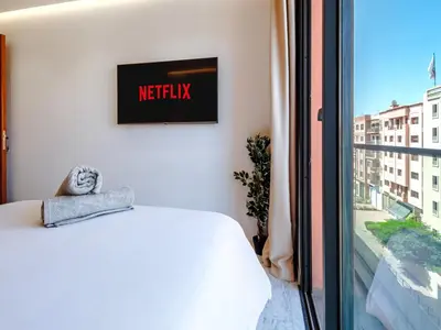 a bedroom with a bed and a tv on the wall at Style et Comfortable au Centre de la Ville in Marrakech