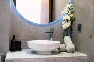 a bathroom with a sink and a mirror and flowers at Style et Comfortable au Centre de la Ville in Marrakech