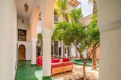 a courtyard with a couch and trees in a building at Riad Akasia in Marrakech
