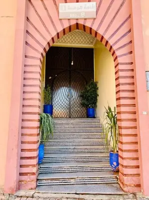 an entrance to a building with an arch with potted plants at Appart Moderne Calme & Climatisé in Marrakech
