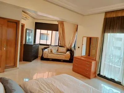 a bedroom with a bed and a dresser in it at Family Apartment with Pool in Marrakech