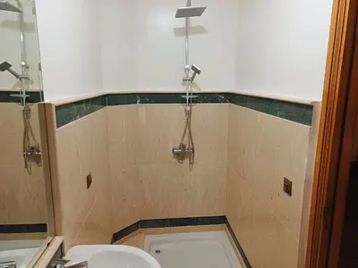 a bathroom with a toilet and a cross on the wall at Family Apartment with Pool in Marrakech