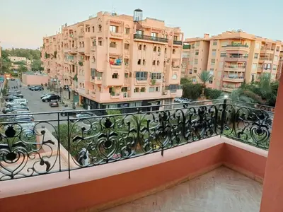 a balcony with a view of a city with buildings at Family Apartment with Pool in Marrakech