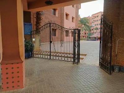 a black gate on a street with a building at Family Apartment with Pool in Marrakech