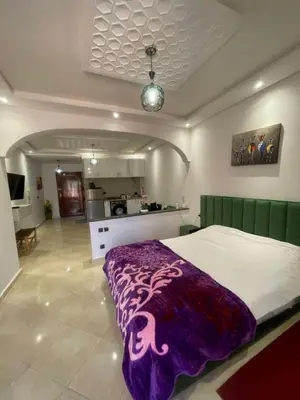 a bedroom with a bed with a purple blanket on it at Un agréable studio in Marrakech
