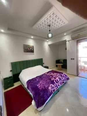 a bedroom with a bed with a purple blanket at Un agréable studio in Marrakech