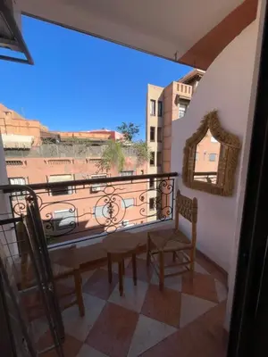 a balcony with chairs and a view of a building at Un agréable studio in Marrakech