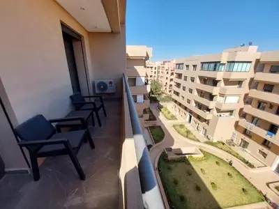 a balcony with chairs and a view of a building at Palm Appart in Marrakech