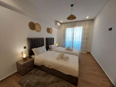 a bedroom with two beds and a window at Palm Appart in Marrakech