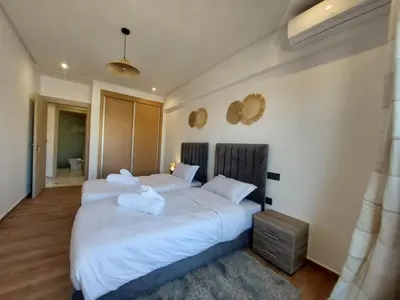 a bedroom with two beds with towels on them at Palm Appart in Marrakech