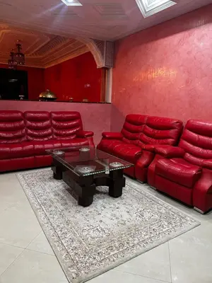 a living room with red leather couches and a coffee table at Riad Jasmine SYBA in Marrakech