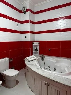 a red and white bathroom with a tub and a toilet at Riad Jasmine SYBA in Marrakech