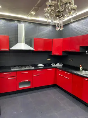 a red kitchen with red cabinets and a chandelier at Riad Jasmine SYBA in Marrakech