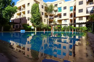 a swimming pool in front of a building at Cozy & Chic Appart Haut Standing Résidence Piscine in Marrakech