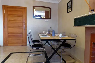 a table and chairs in a room with a door at Cozy & Chic Appart Haut Standing Résidence Piscine in Marrakech