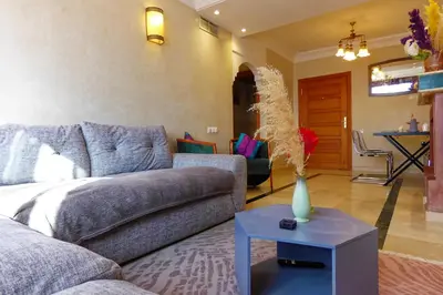 a living room with a couch and a table at Cozy & Chic Appart Haut Standing Résidence Piscine in Marrakech