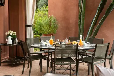 a dining table and chairs with a meal on it at Exceptional villa on 10,000 meter square with heated pool in Marrakech