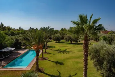 an aerial view of a yard with a swimming pool and palm trees at Exceptional villa on 10,000 meter square with heated pool in Marrakech
