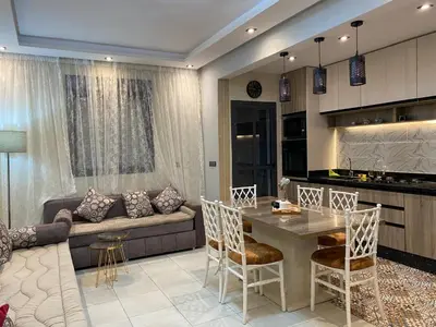 a kitchen and living room with a table and a couch at appartement in Marrakech