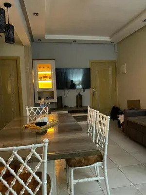 a living room with a wooden table and chairs at appartement in Marrakech
