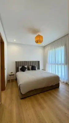 a bedroom with a large bed and a window at Magnifique appartement prestigia in Marrakech