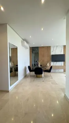 a living room with a table and chairs in it at Magnifique appartement prestigia in Marrakech