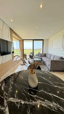 a living room with a vase on a table at Magnifique appartement prestigia in Marrakech