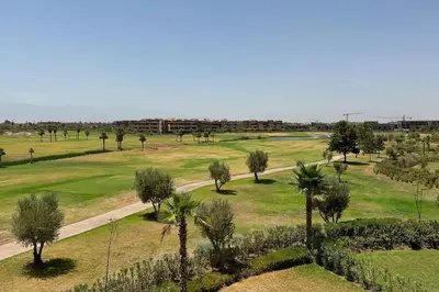 an aerial view of a park with palm trees and a road at Magnifique appartement prestigia in Marrakech