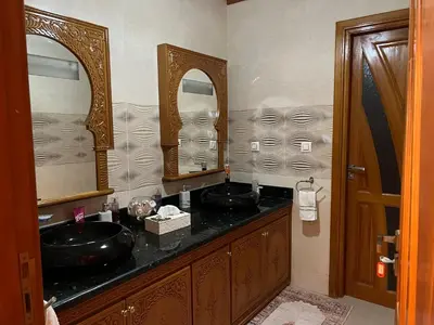 a bathroom with two sinks and two mirrors at Villa La Baraka in Marrakech