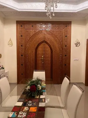 a dining room with a table and chairs and a wooden door at Villa La Baraka in Marrakech
